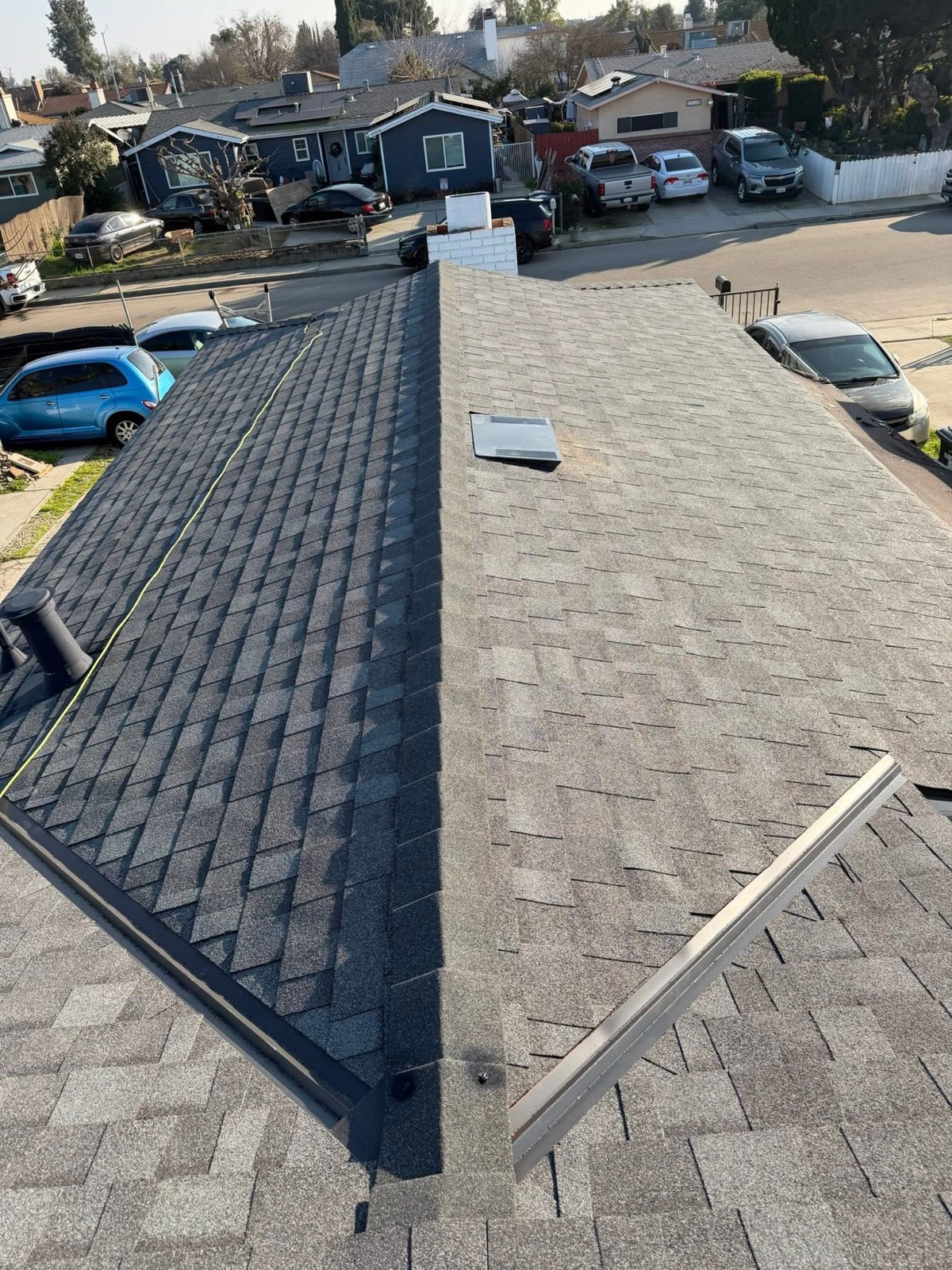 Completed gray shingle roof with ridge and flashing details
